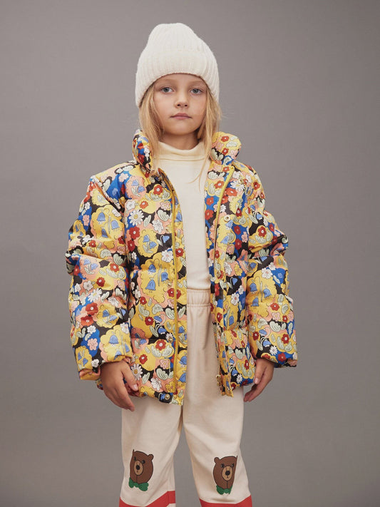 child wearing multi color coat in front of gray background