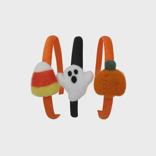 Three Halloween-themed headbands with candy corn, ghost, and pumpkin designs on a light gray background.