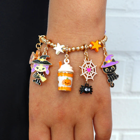 Bracelet with Halloween-themed charms on a wrist against a black and white background